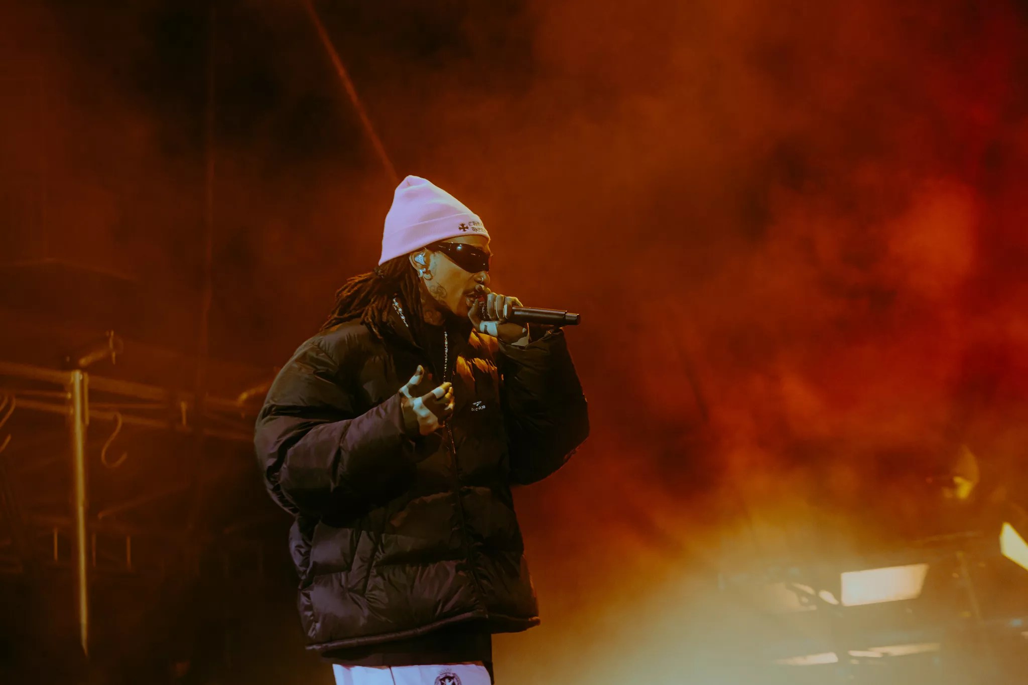 man in pink beanie rapping at a microphone