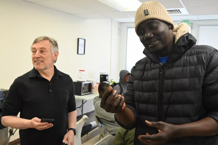 A Mauritanian migrant holds up a leafy green.