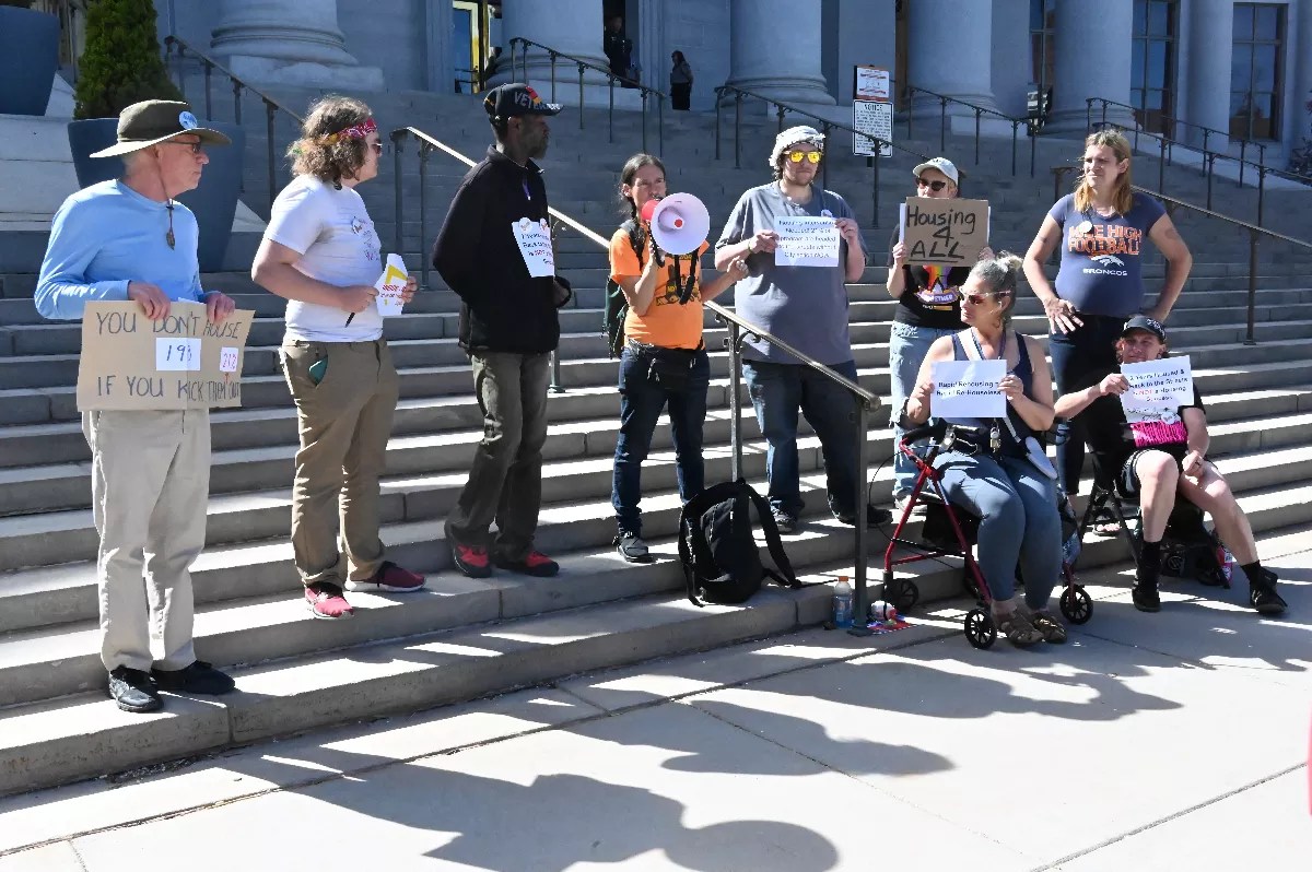 Activists hold signs at Denver City and County Building