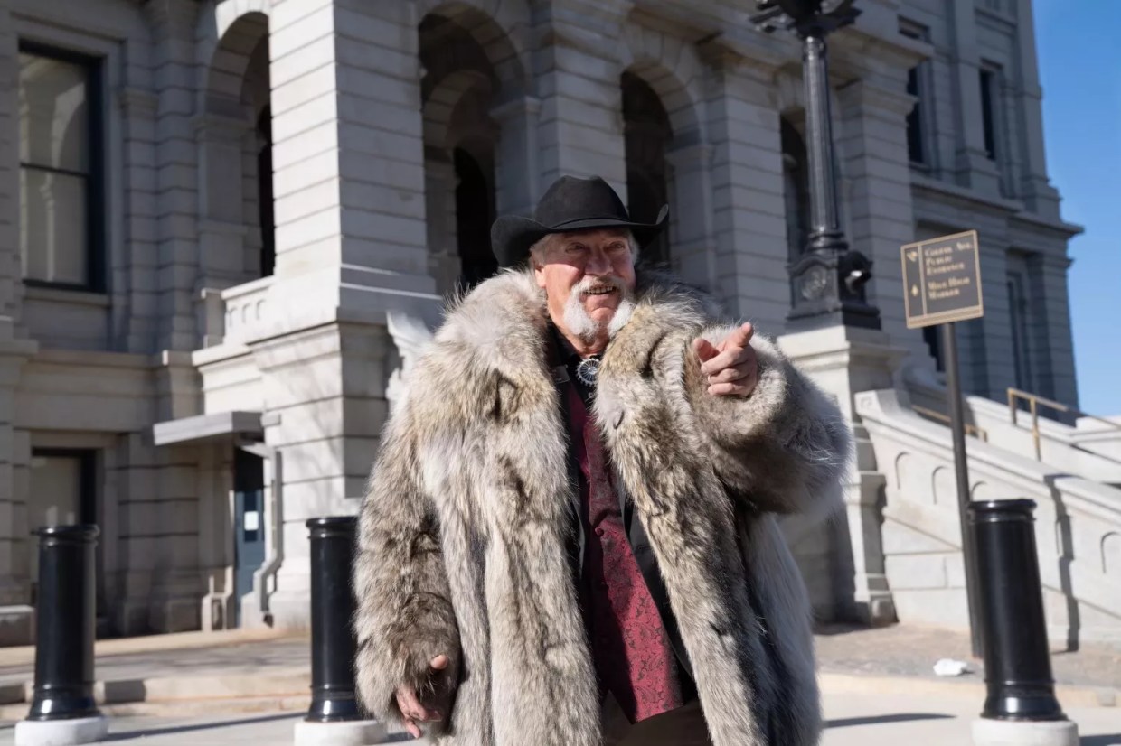 Senator Perry Will sporting a wolf fur jacket and bolo tie.