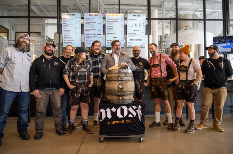Group of people with a traditional barrel tapping.
