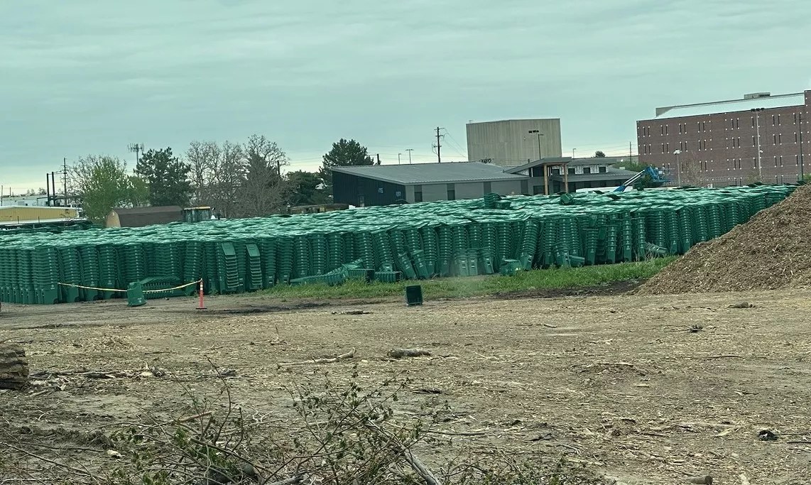 Green compost bins stacked in a field