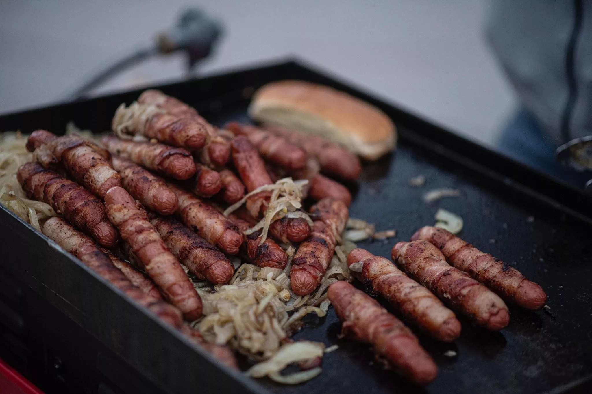 Hot dogs onions and buns on the grill