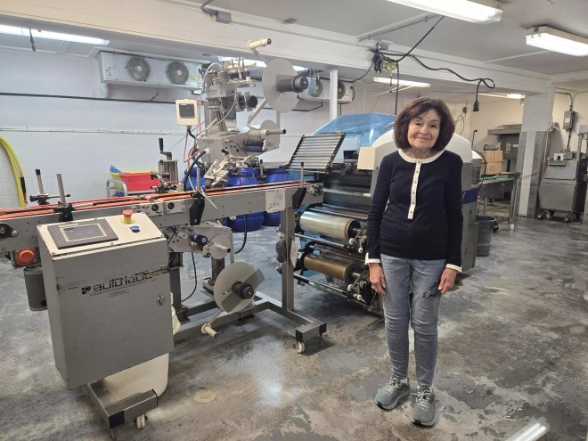 a woman standing inside a sausage production facility