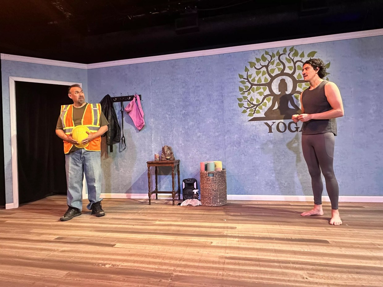 a construction worker and yoga teacher in a yoga studio set in a theater