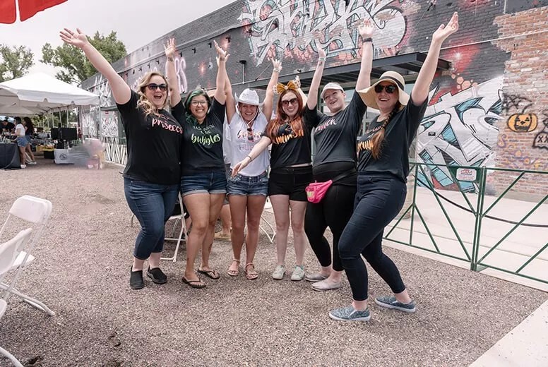 a group of women posting with their arms in the air