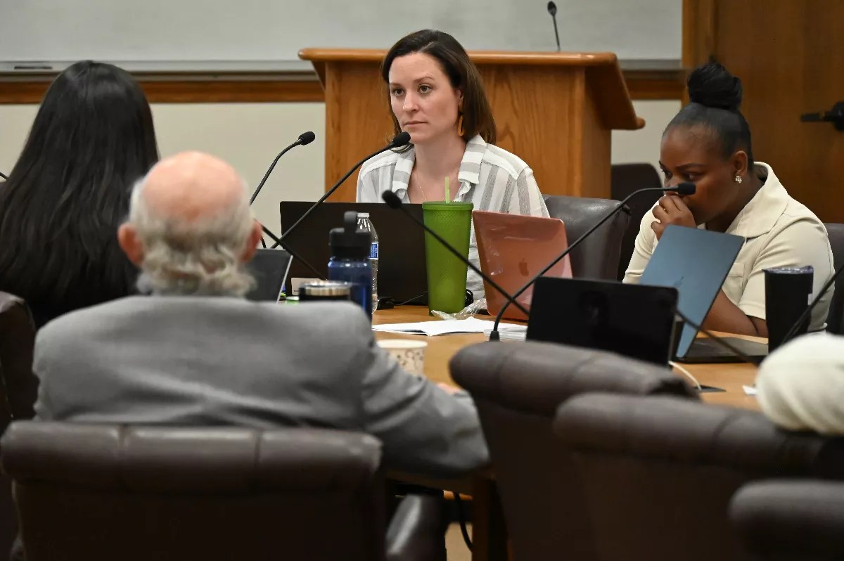 A woman listens at a conference.