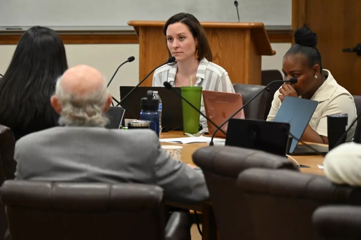 A woman listens at a conference.