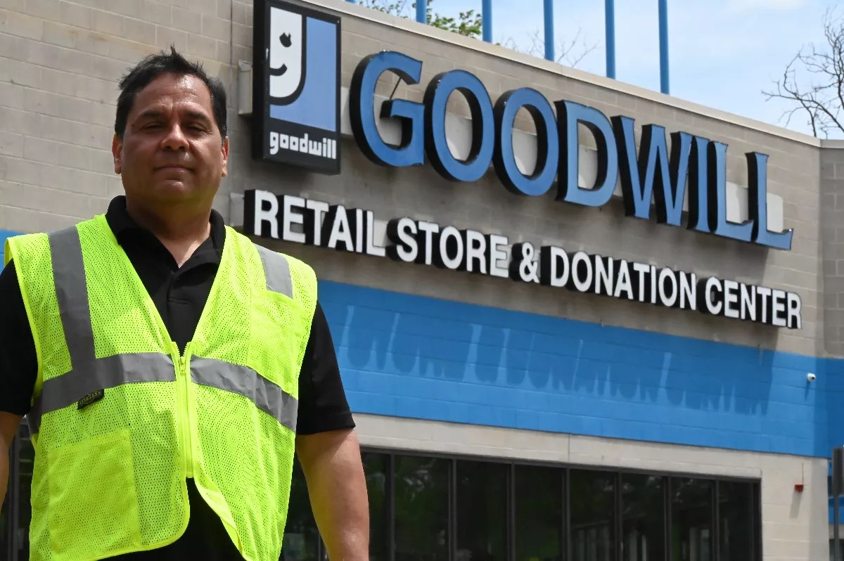 A man stands in front of a store.