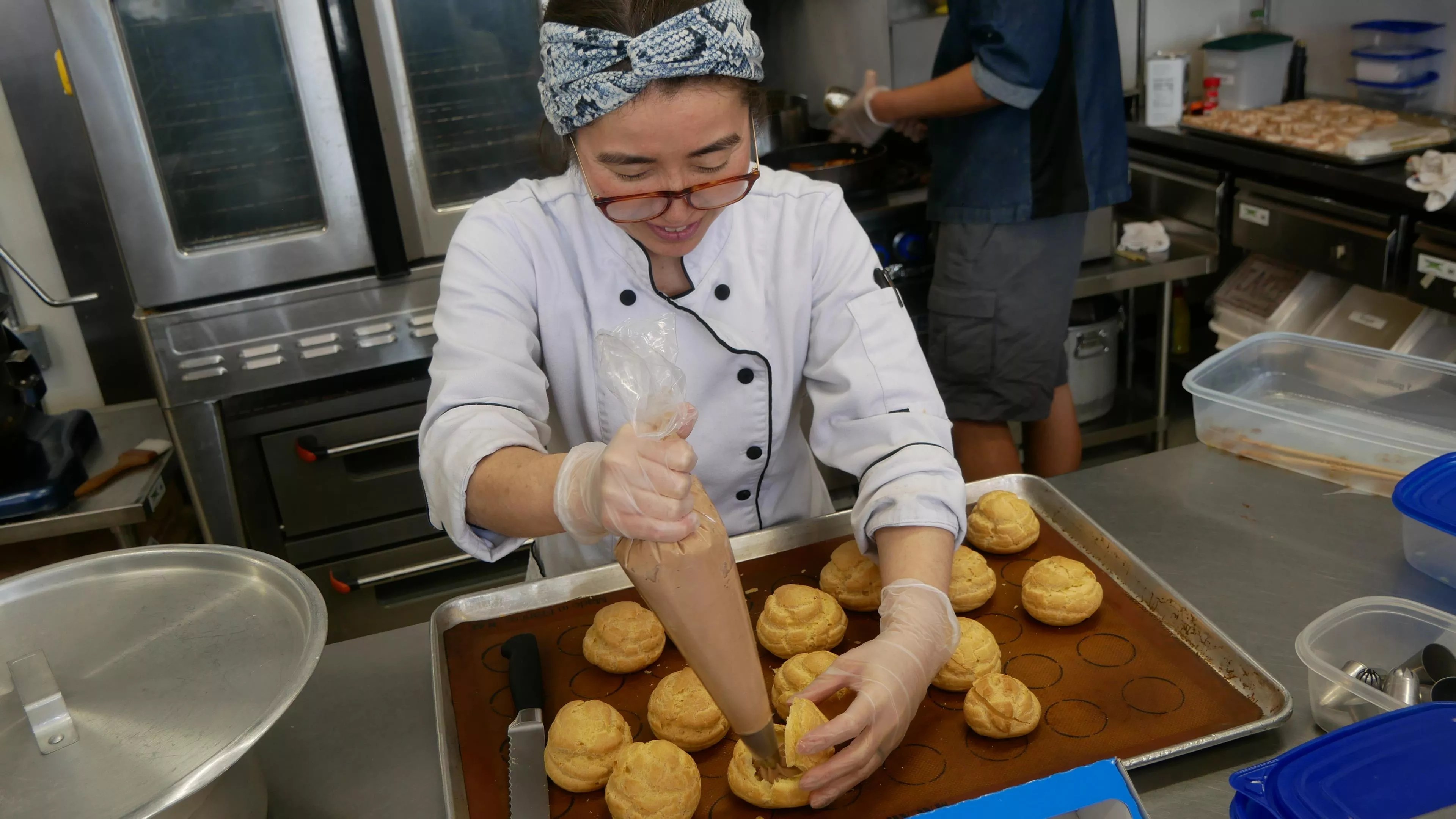 woman in a chef coat holding a pastry bag