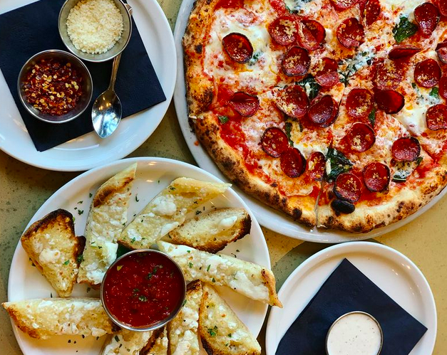a pepperoni pizza and slices of garlic bread