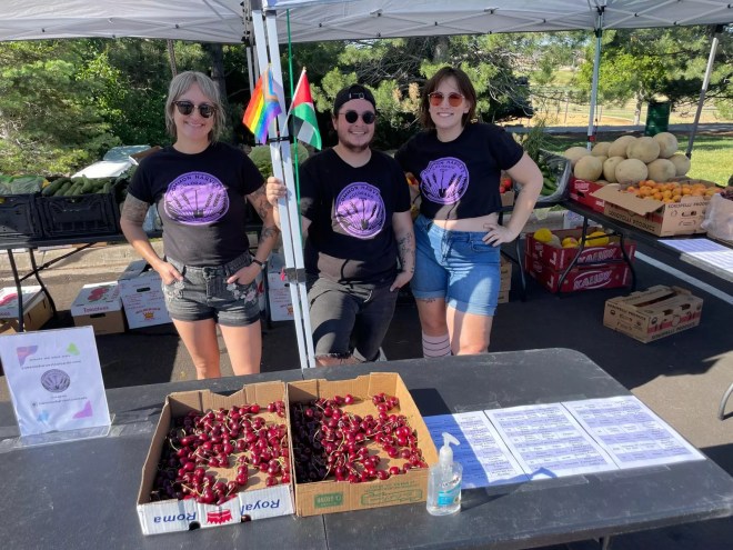 The three Common Harvest Colorado co-founders underneath a tent at a farmers market