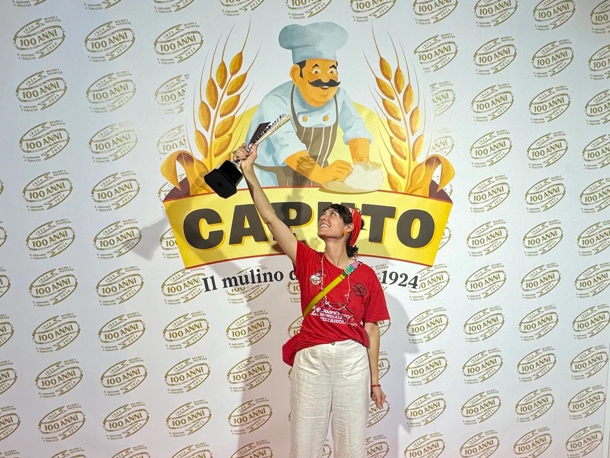 woman in a red shirt holding a trophy in the air