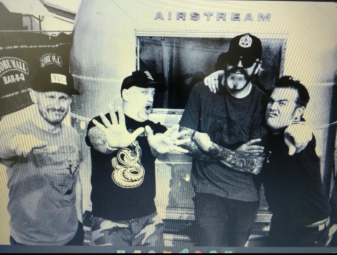 punk band poses for photo in front of Airstream