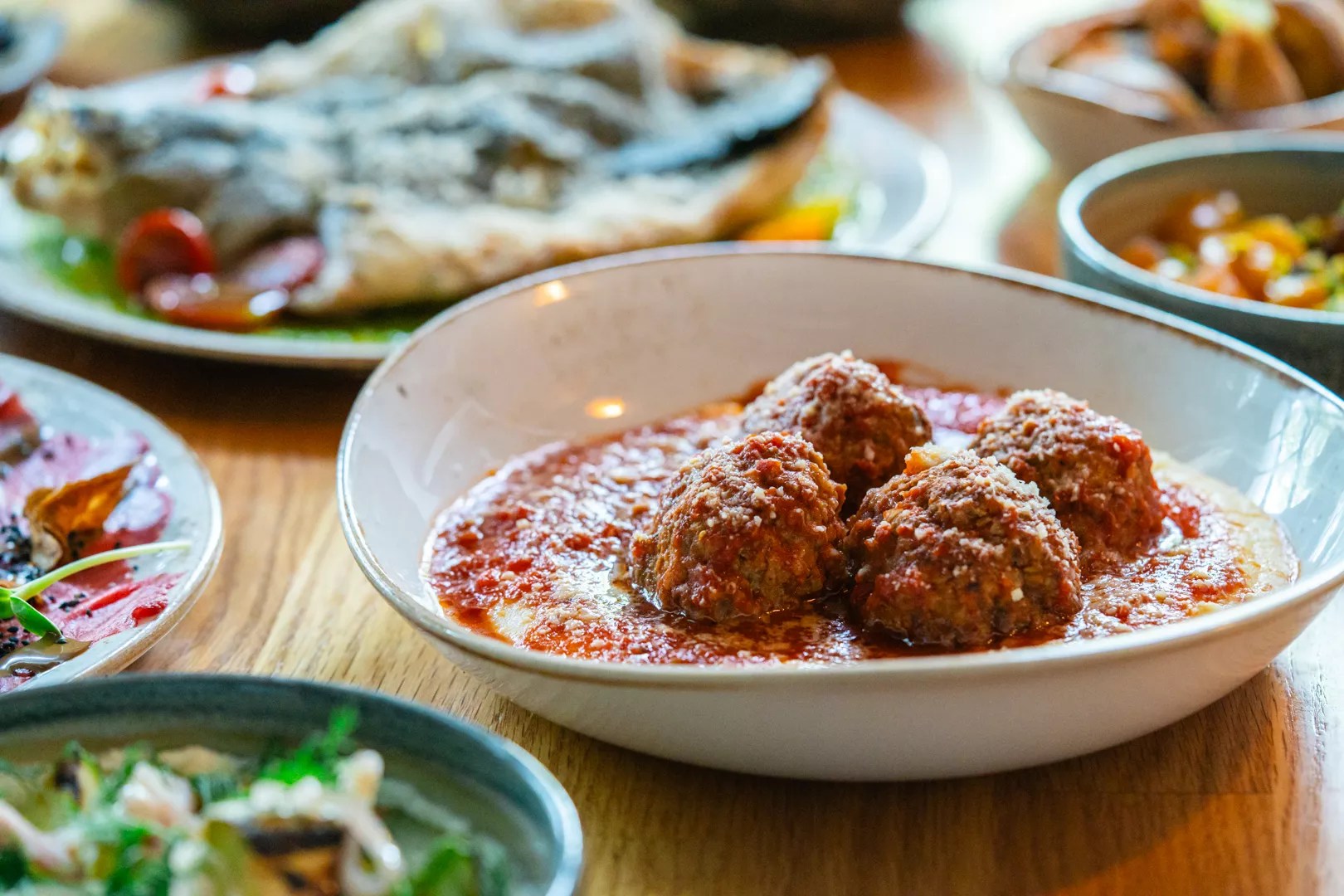 a plate of meatballs over polenta