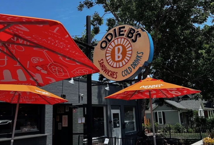 orange umbrellas on a patio and a sign that says "odie b's"