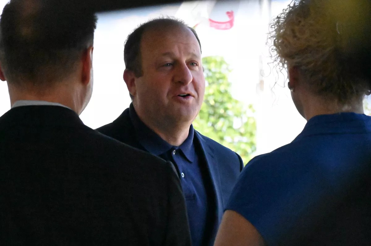 A man talks to two people.