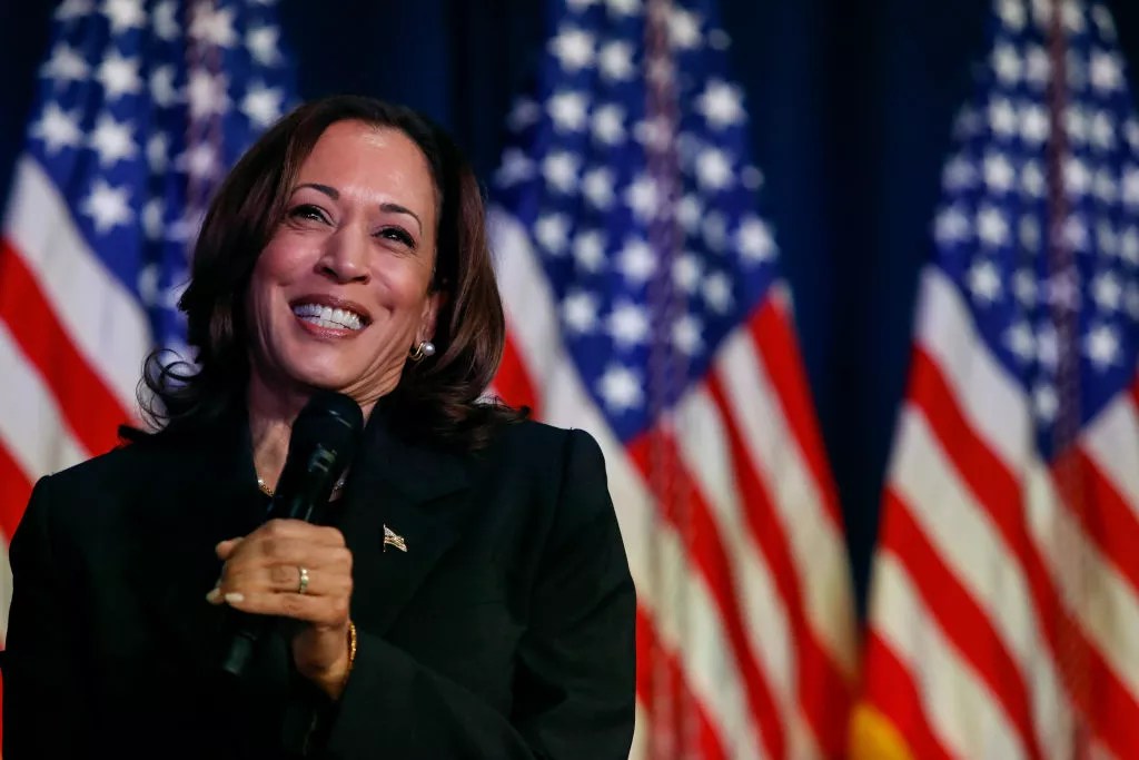 kamala harris in front of flags.
