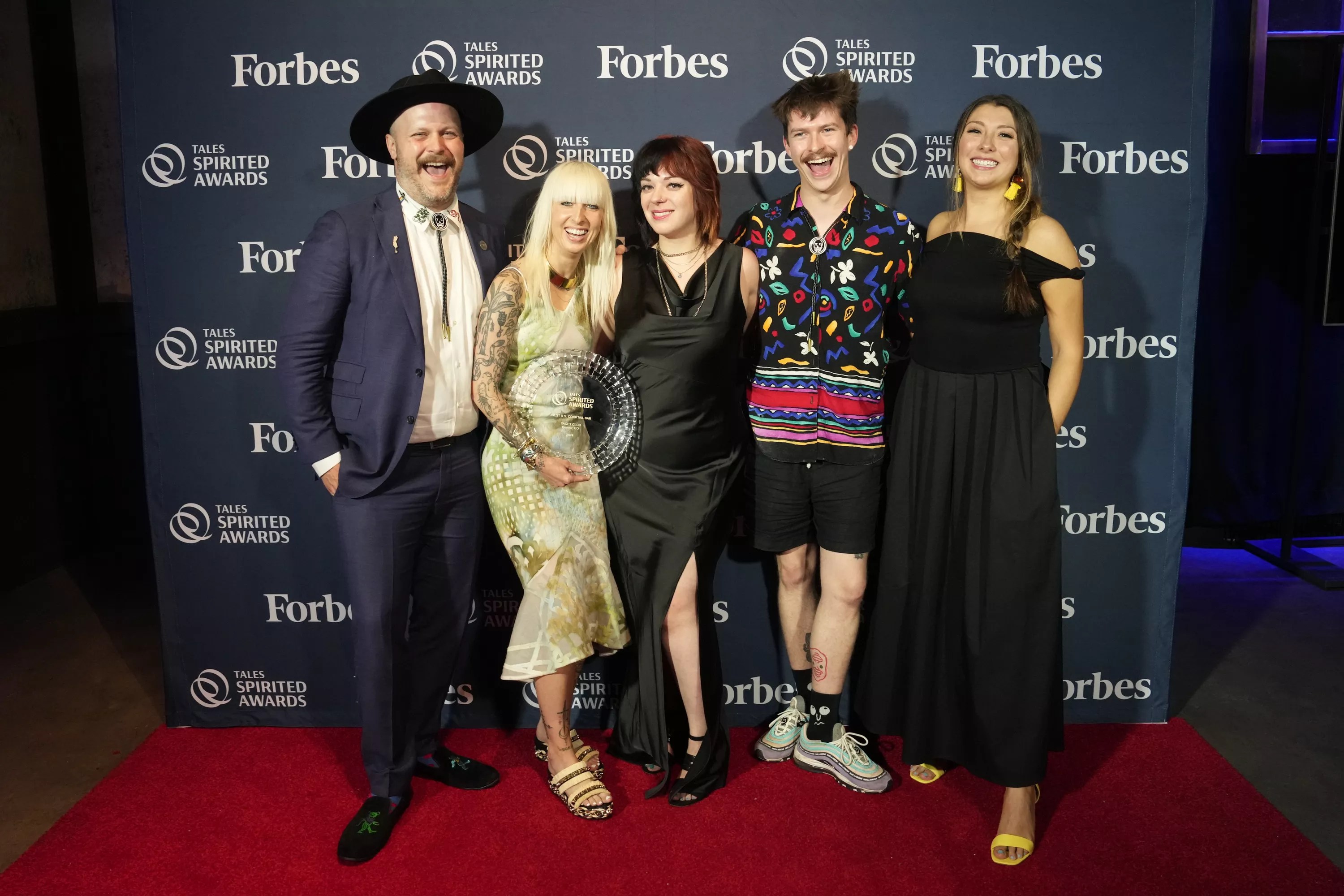 a group of people posing on a red carpet