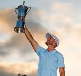 Golfer Wyndham Clark holds his U.S. Open trophy