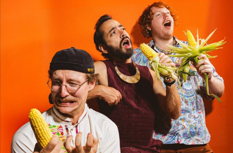 three men holding corn