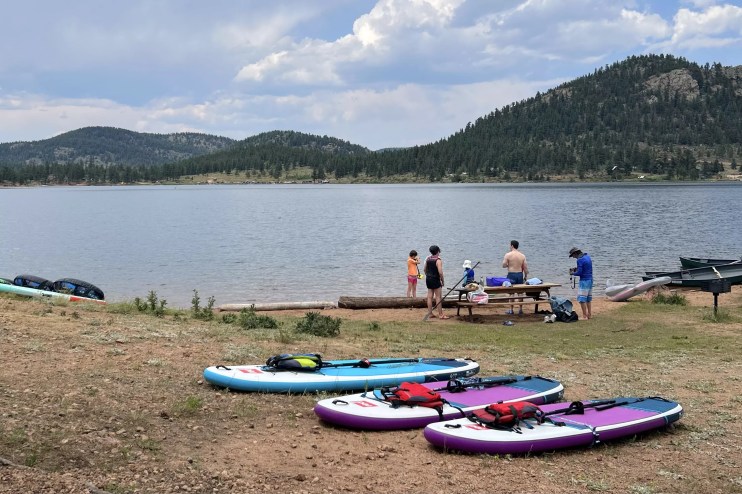 Paddleboards and a group of people along the shore at Wellington Lake
