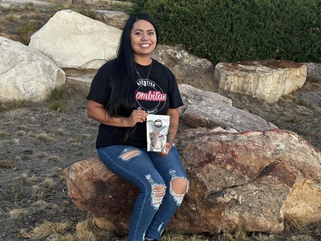 woman posed outdoors with a Bombitas birria bomb package