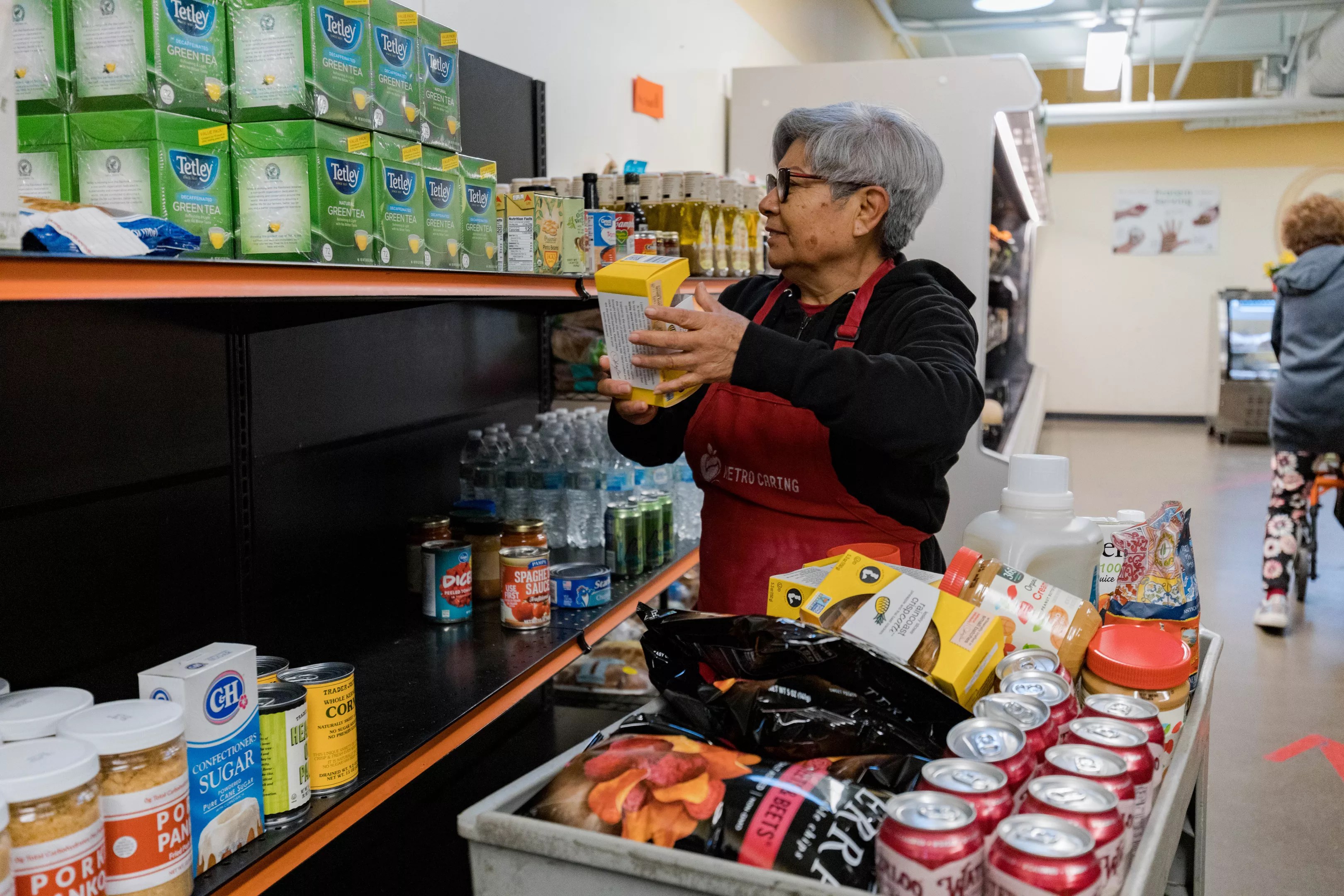A Metro Caring volunteer stocking shelves at its charitable market