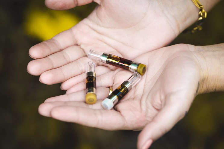 THC vape cartridges in a pair of hands