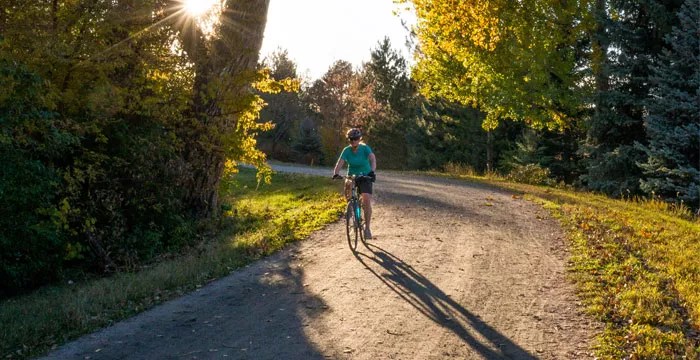 man on bicycle under fall leaves