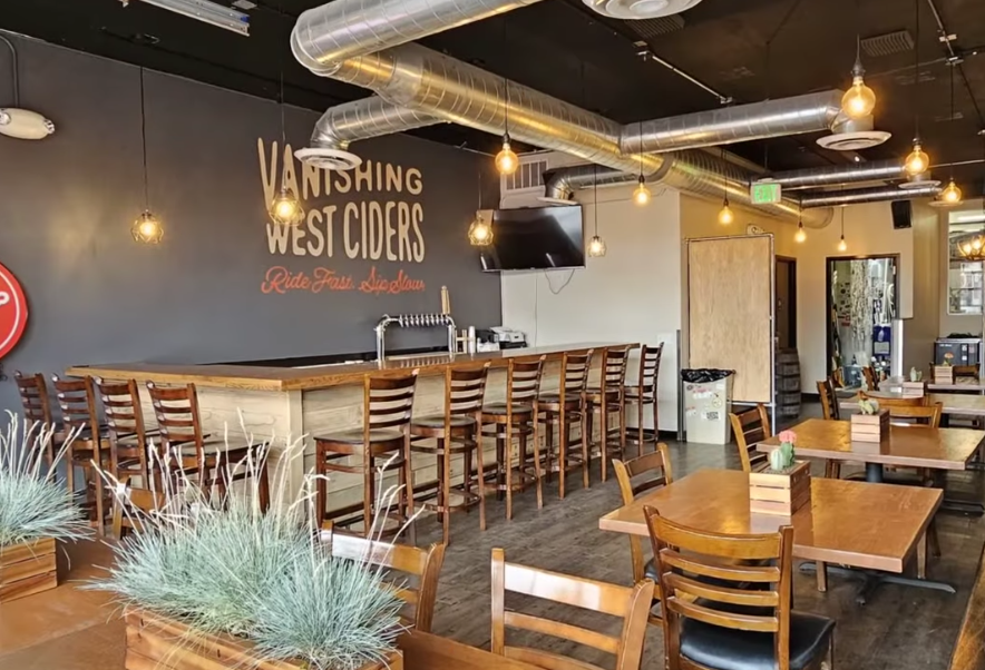 tables and a bar inside a cidery
