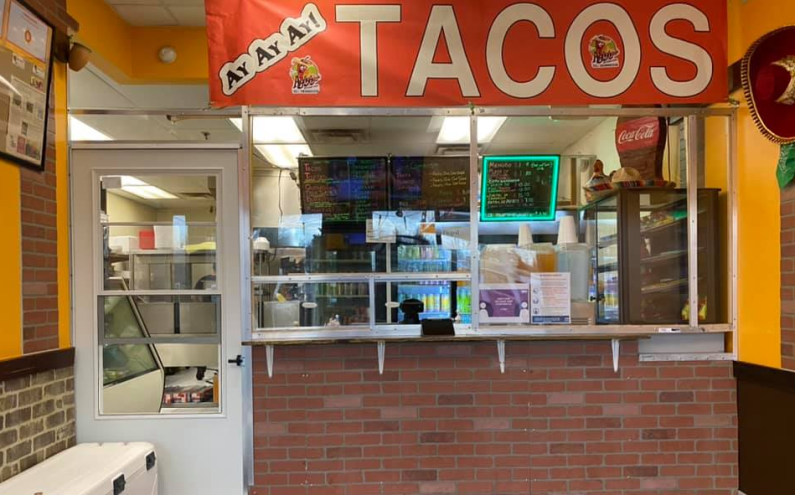 "tacos" sign above a counter