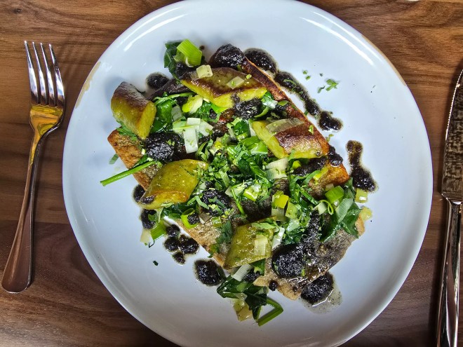 trout with spinach gnudi on a plate