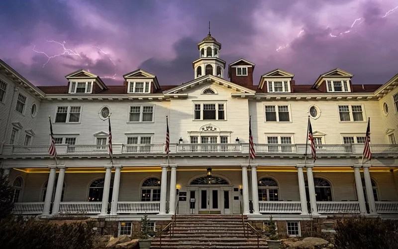 The exterior of the Stanley Hotel backdropped by a stormy sky
