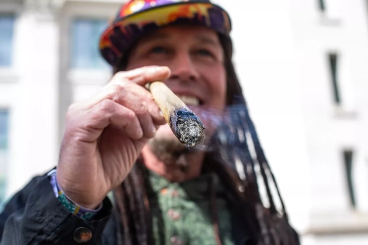 White guy with dreadlocks smoke joint