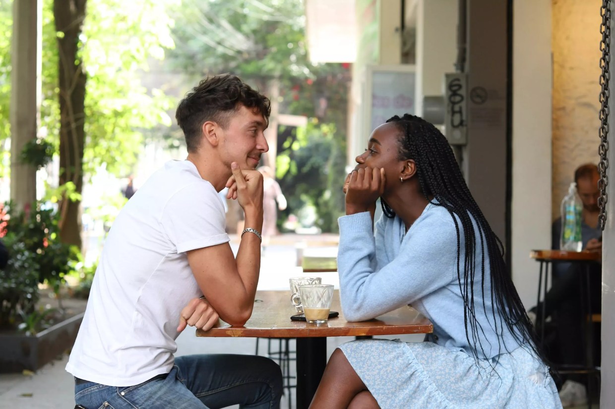 white man and black woman at table.