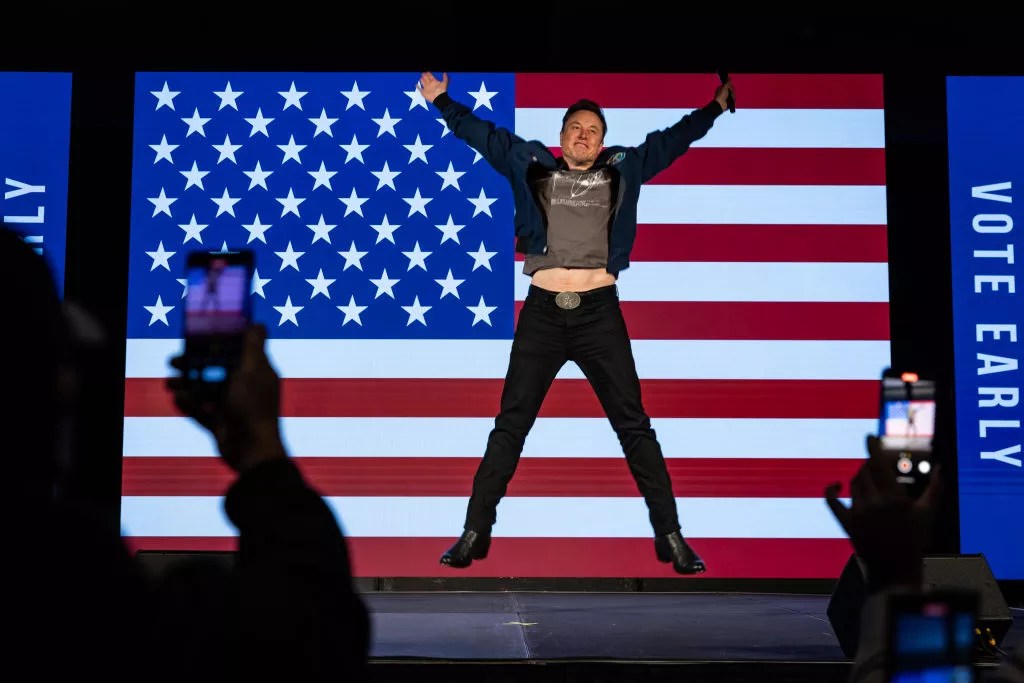 man jumping in front of flag