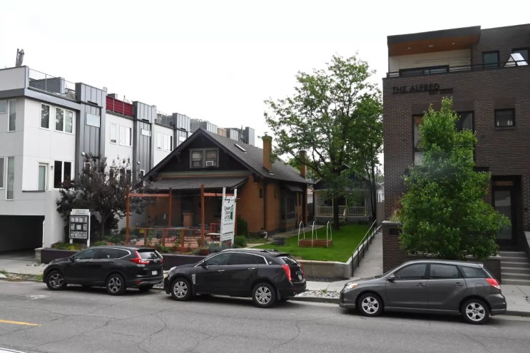 A house is between tall apartments.