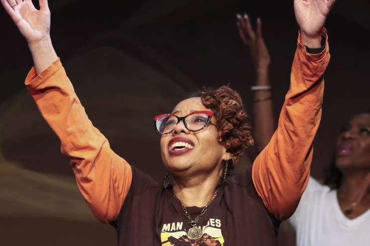 Black woman with hands in the aiir