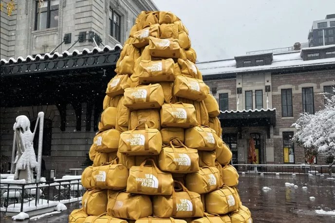 A tree-shaped stack of yellow North Face duffle bags outside of Union Station