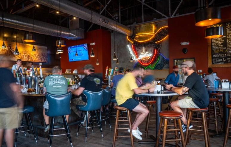people sitting at tables inside a bar