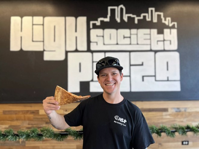 man holding slice of pizza
