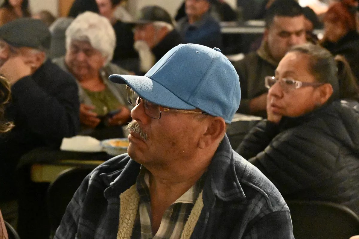 A man listens in a crowd.