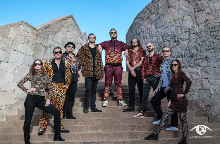 bandmates wearing tiger stripes pose for a picture