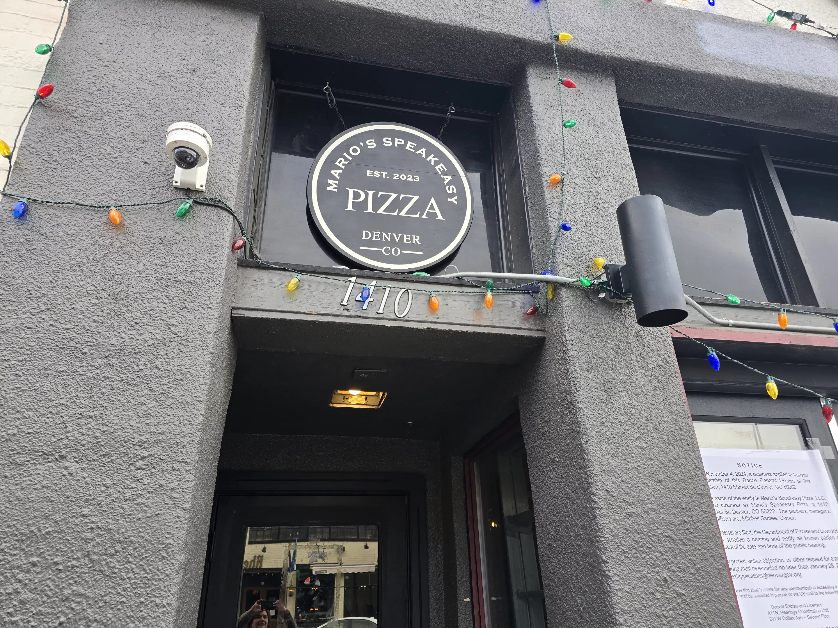 "mario's speakeasy pizza" sign over a doorway