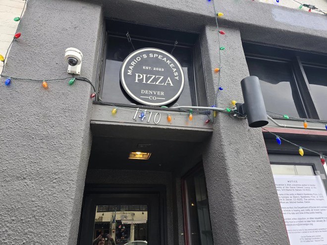 "mario's speakeasy pizza" sign over a doorway