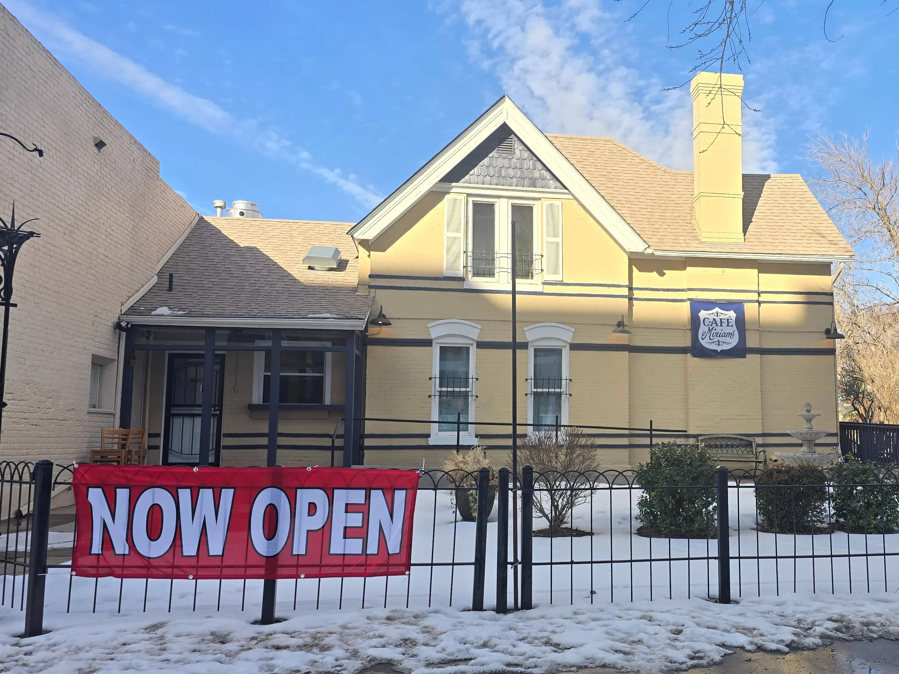 "now open" sign in front of a building