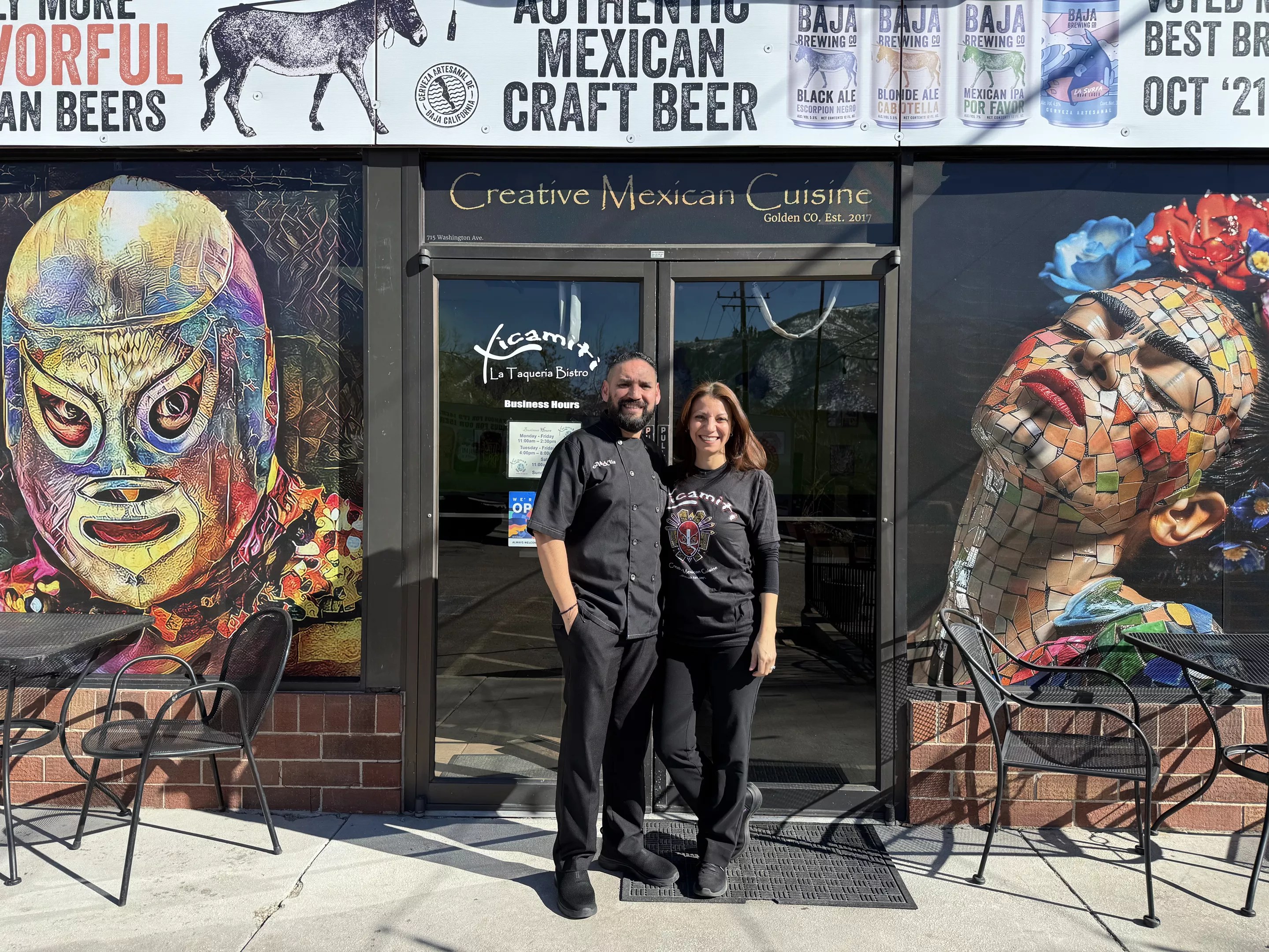 man and woman standing in front of a restaurant front door