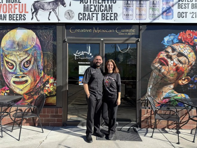man and woman standing in front of a restaurant front door
