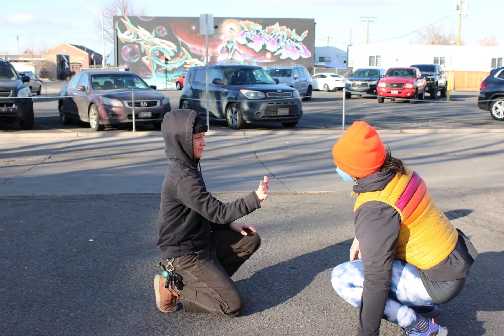 A mirroring game is played by two people in a parking lot.